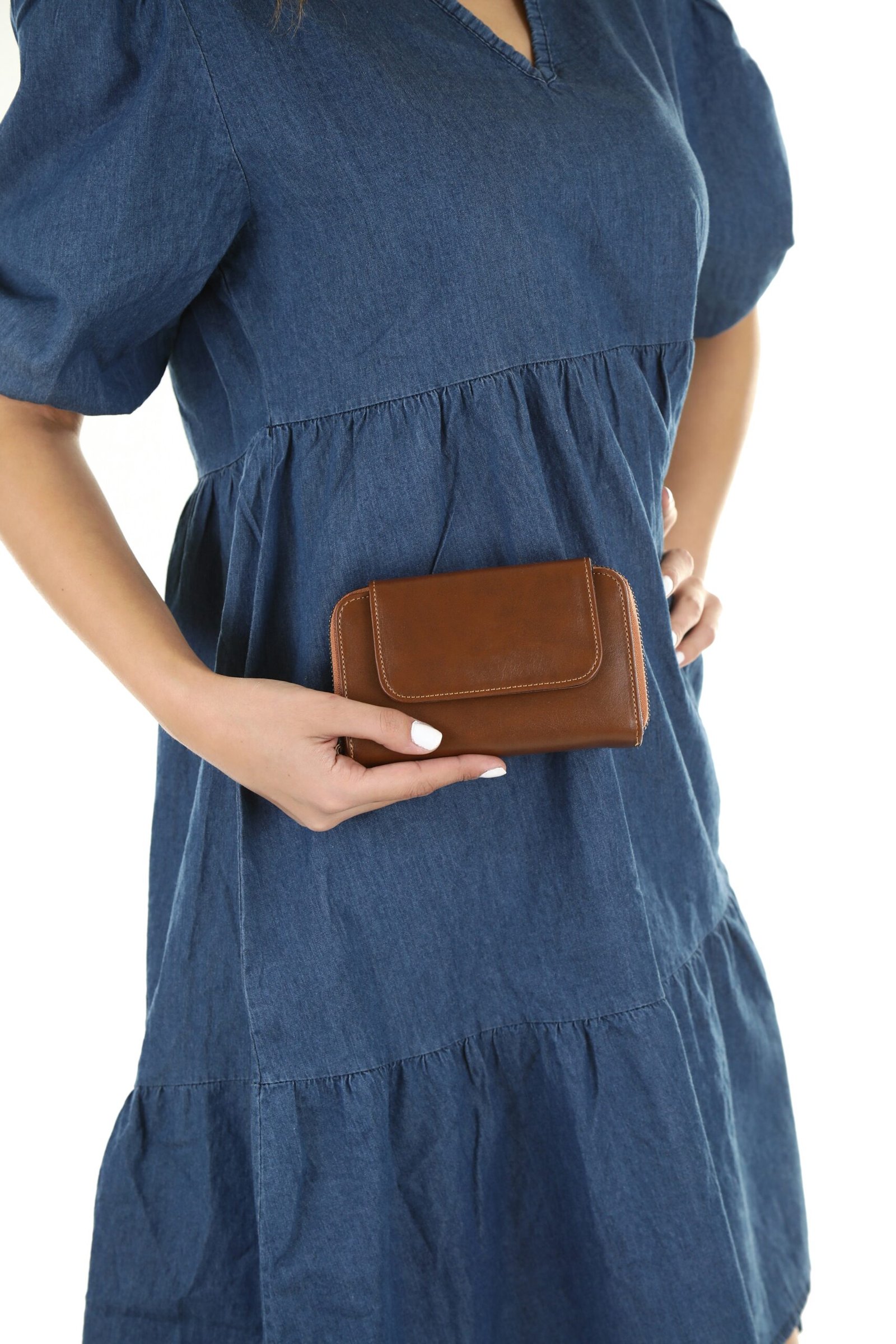 a woman in a blue dress holding a brown purse